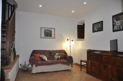 a living room with a couch and a television at La Casa sull'Archetto in Corciano
