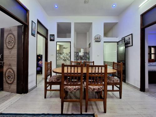 Un comedor con mesa y sillas de madera. en Tara Home Stay, en Udaipur