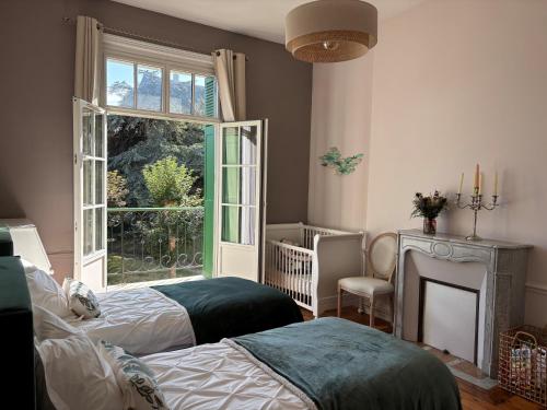 a bedroom with two beds and a large window at Appartement bien équipé ultra confort - Sur la plage - Parking privé - gardien in Dinard