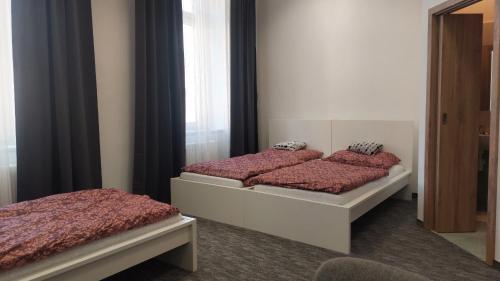 two twin beds in a room with a mirror at Penzion TGM in Příbram