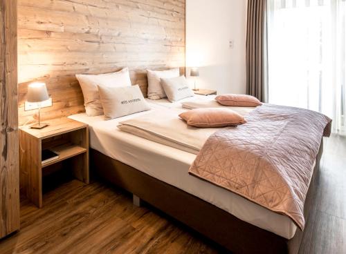 a bedroom with a large bed with a wooden wall at Hotel Winterberg Resort in Winterberg