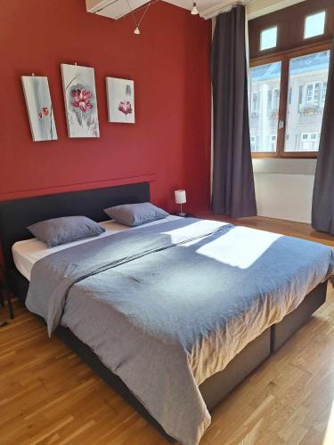 una camera da letto con un letto grande con una parete rossa di Charmant Duplex Historique au Cœur de Liège a Liegi