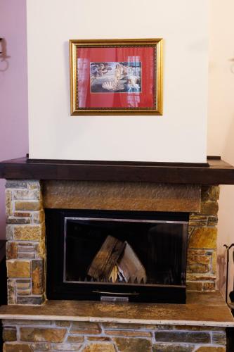 a fireplace with a white wall above it at Luxury Guesthouse Pantheon in Palaios Panteleimon