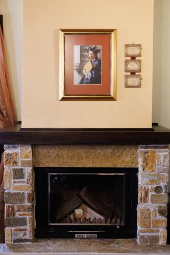 a picture above a fireplace with a picture on the wall at Luxury Guesthouse Pantheon in Palaios Panteleimon