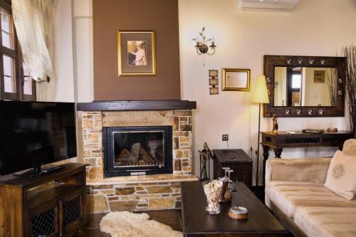 a living room with a fireplace and a couch at Luxury Guesthouse Pantheon in Palaios Panteleimon
