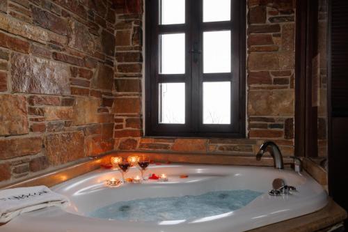 a bath tub with candles and wine glasses in it at Luxury Guesthouse Pantheon in Palaios Panteleimon