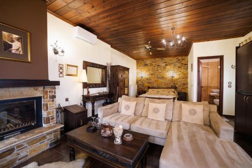 a living room with a bed and a fireplace at Luxury Guesthouse Pantheon in Palaios Panteleimon