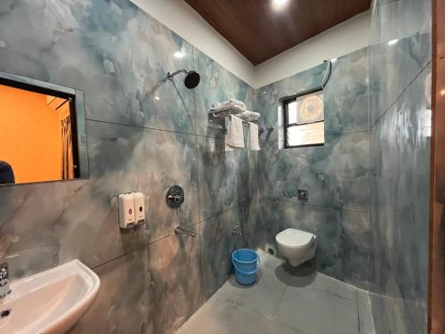 a bathroom with a toilet and a sink at Anjana Resort and Convention in Bhubaneshwar