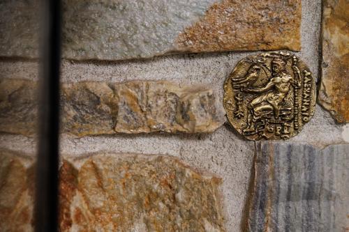 a coin on the side of a stone wall at Luxury Guesthouse Pantheon in Palaios Panteleimon