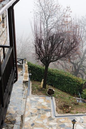 a tree sitting next to a stone walk way at Luxury Guesthouse Pantheon in Palaios Panteleimon