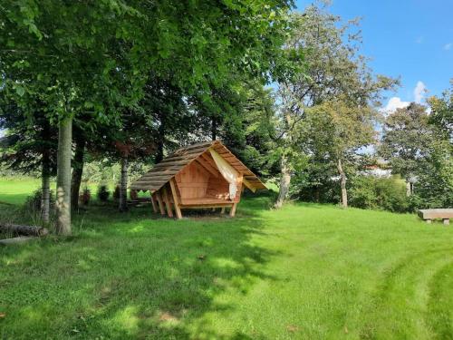 a small wooden cabin in a field with trees at UNIKT studio med PRAGTFULD udsigt og absolut RO in Frederikshavn