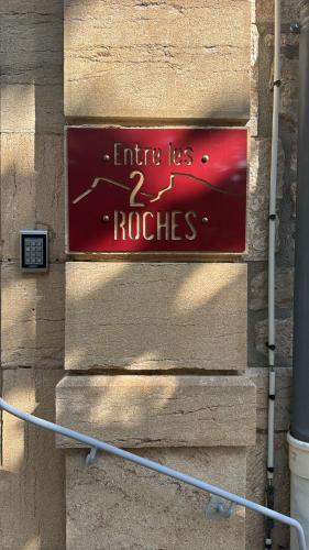 a red sign on the side of a building at Appartement - Parking Free - Hôtel Entre les 2 Roches in Prissé