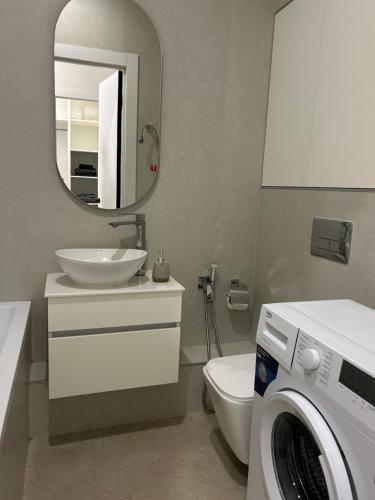 a bathroom with a washing machine and a washer at Квартира in Almaty