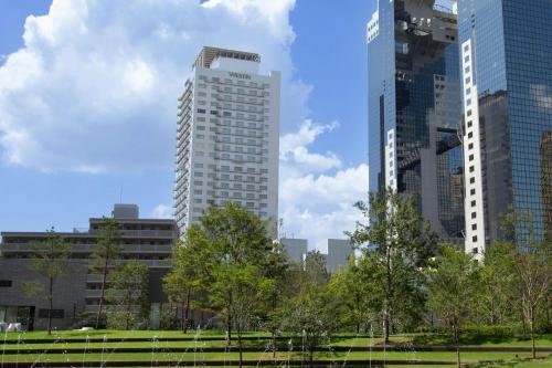 a city skyline with tall buildings and a park at The Westin Osaka in Osaka