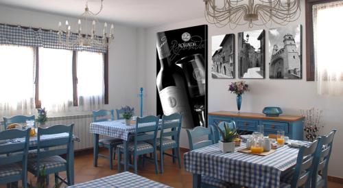 un comedor con mesas y sillas y una botella de vino en Casa Rural Rojanda, en Elciego