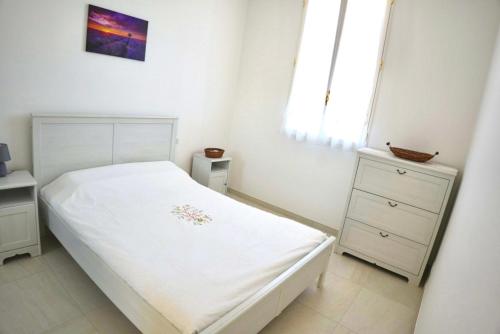 une chambre blanche avec un lit blanc et une commode dans l'établissement La Belle Époque du Sud - lumineux et authentique, à La Colle-sur-Loup