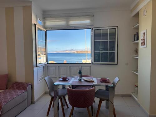 a living room with a table and chairs and a large window at Casa Alejandro II in Tarajalejo