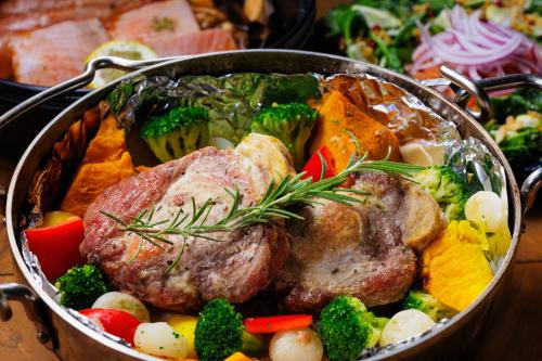 a pan filled with meat and vegetables on a table at From P in Hakuba