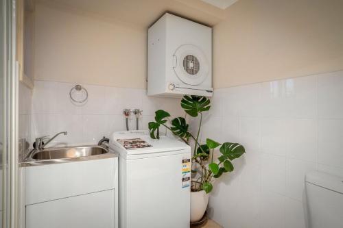 a small kitchen with a sink and a white refrigerator at Milton Village Retreat - secluded comfort in Milton