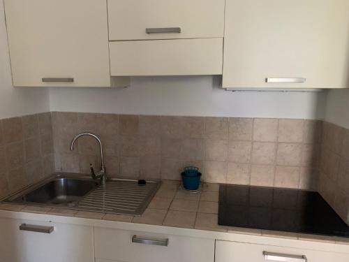 a kitchen counter with a sink and white cabinets at Sofis Servizi Rio Grande (CAV) in Principina a Mare