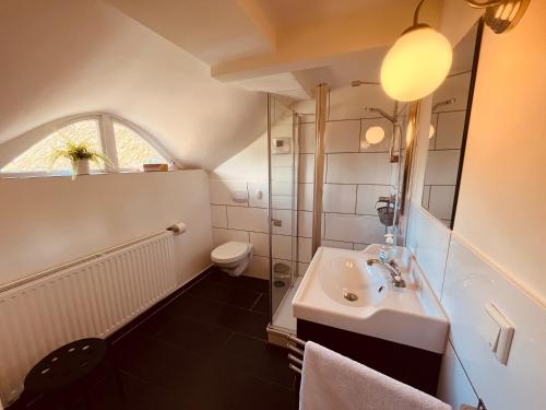 a bathroom with a sink and a toilet at Ferienwohnung de lütte Leive in Born in Born