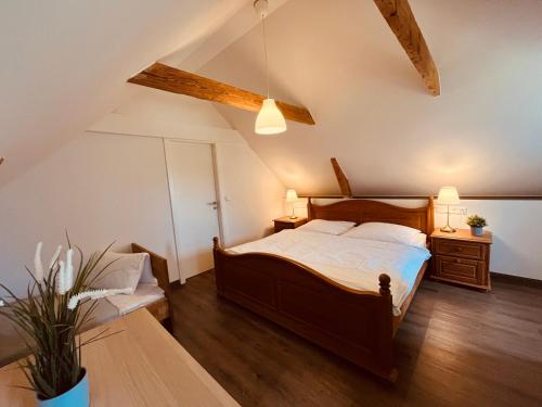 a bedroom with a wooden bed and a table at Ferienwohnung de lütte Leive in Born in Born
