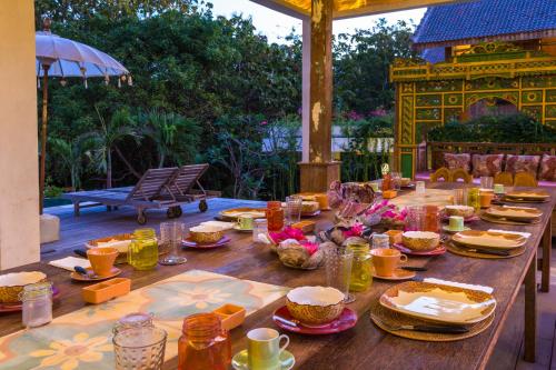 a long wooden table with food on a patio at BoHo Bingin Beach Bali in Uluwatu