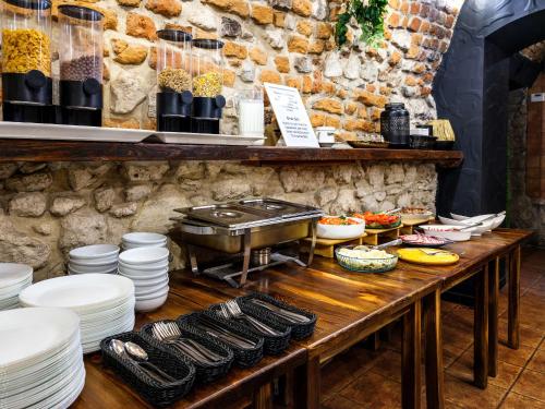 een tafel met borden en een grill bij Hotel Rezydent in Krakau