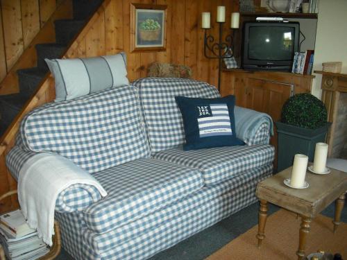 a living room with a couch and a tv at Charmantes Cottage im Landhausstil in Kearsney, Dover 