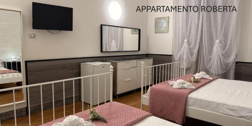 a bedroom with two beds and a tv in it at Roberta in Bologna