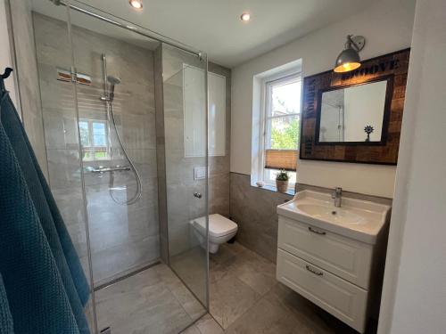 a bathroom with a shower and a toilet and a sink at Boddenkutter in Born