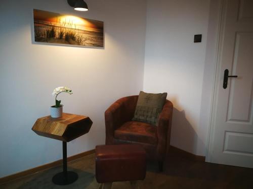a living room with a chair and a table at Boddenkutter in Born