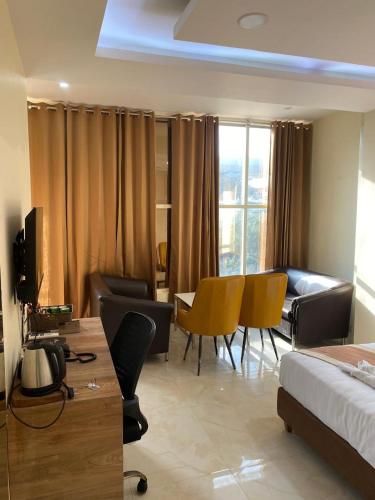 a hotel room with a bed and a table and chairs at Immense Residency in Faridabad