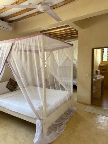 a bedroom with a bed with a mosquito net at Seaside Villa 1 & Seaside Villa 2 at 'Tamani' in Diani Beach