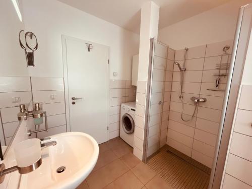 a bathroom with a sink and a washing machine at Hus MiGa in Born