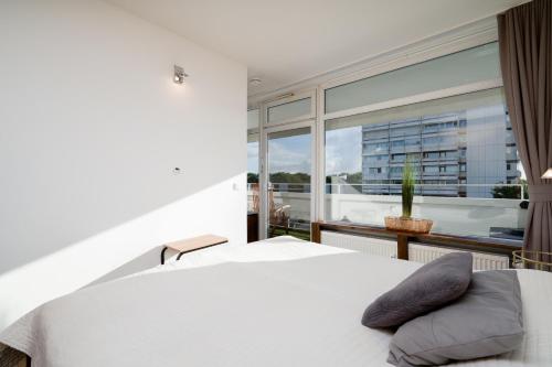 a bedroom with a white bed and a large window at Panoramic B03-1 in Sierksdorf