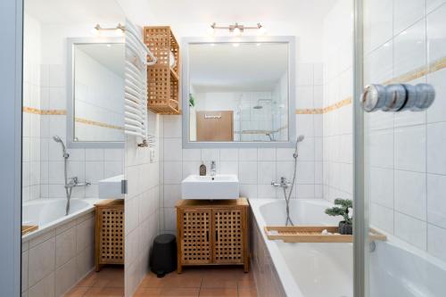 a bathroom with two sinks and a tub and a mirror at Panoramic B03-1 in Sierksdorf