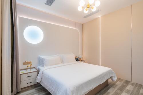 a bedroom with a white bed and a window at Wings by Hawks Hotels Kamadhoo Baa Atoll in Kamadhoo