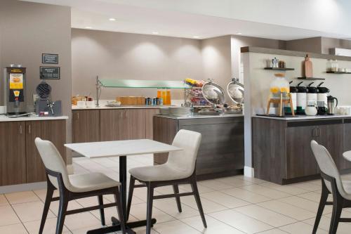 a restaurant with a table and chairs and a kitchen at Residence Inn by Marriott San Antonio Airport/Alamo Heights in San Antonio