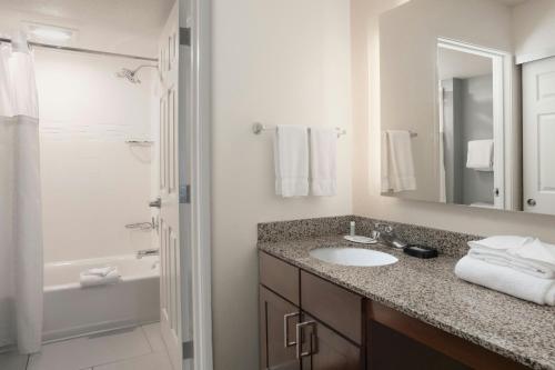a bathroom with a sink and a mirror and a tub at Residence Inn by Marriott San Antonio Airport/Alamo Heights in San Antonio