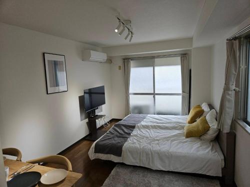 a bedroom with a bed with a teddy bear on it at ホテルレスポワール305 in Tokyo