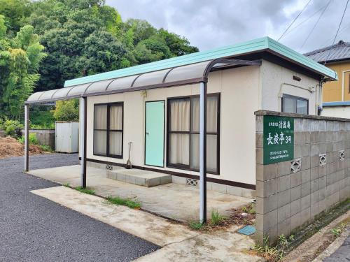 a bus stop with a sign in front of it at まんのう清流庵 in Manno