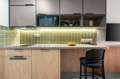 a kitchen with a sink and a black chair at Adina Apartment Hotel Budapest in Budapest