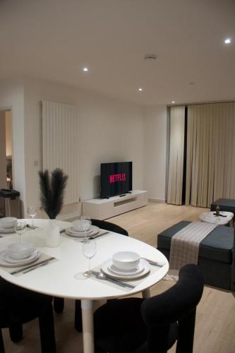 a living room with a white table and a bed at Luxury 2 Bedroom 2 Bathroom Apartment by ExCeL & The 02, London in London