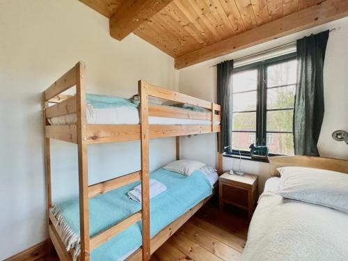 a bedroom with two bunk beds and a window at Villa Nikolaj - Historisches Pastorat in Fehmarn