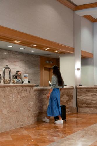 a woman is standing at a counter in a lobby at Westfields Marriott Washington Dulles in Chantilly