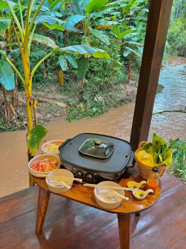 a table with a suitcase on top of a table at PimSook Homestay Riverside ที่พักแม่แตง