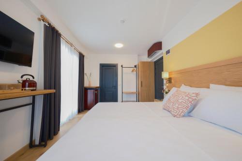 Un dormitorio con una gran cama blanca y un televisor. en Pastel İstanbul, en Estambul