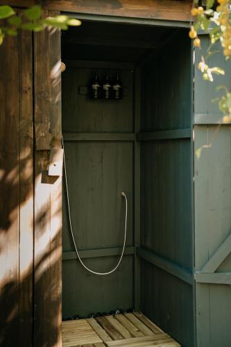 a shower with a hose in a green wall at Forest Home Okoř in Okoř