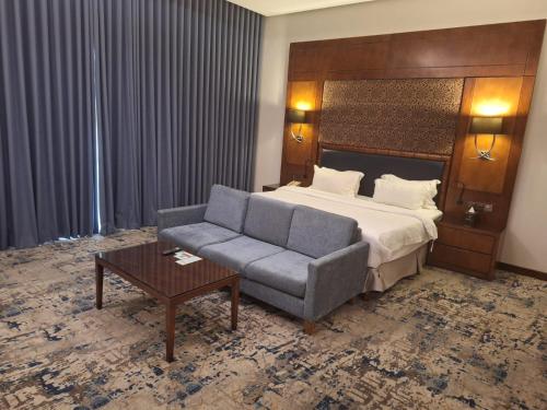 a hotel room with a bed and a couch at Qaser Al Hamra Hotel in Riyadh